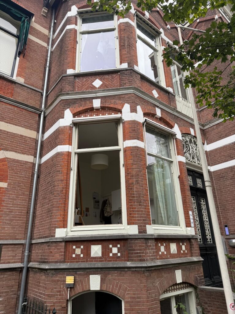 Hoge ramen in de bakstenen gevel van een woning