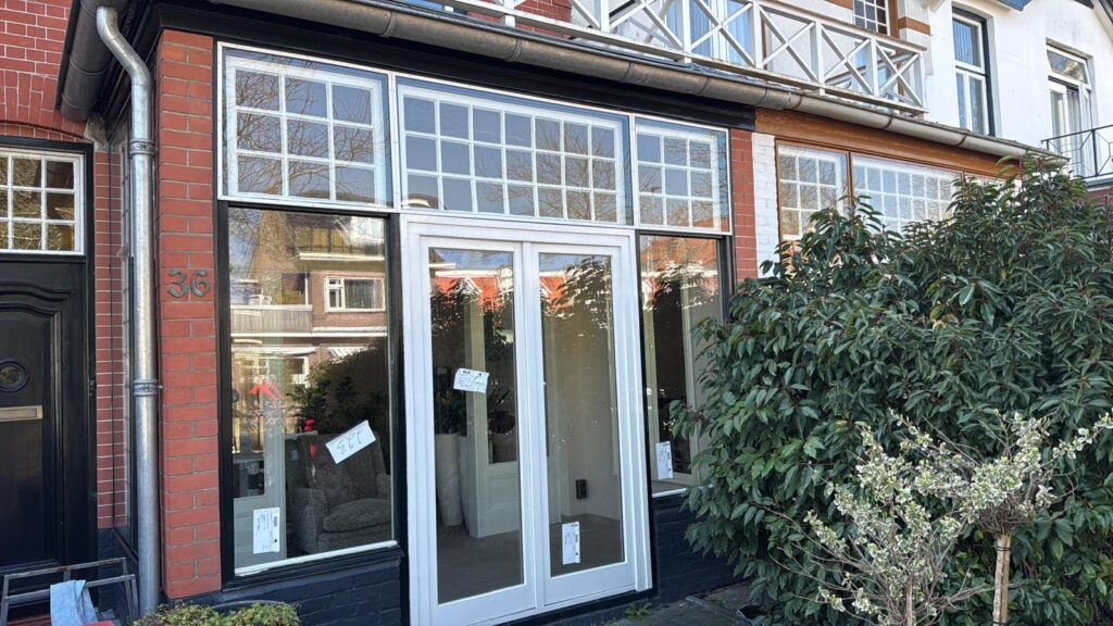 Beglazing in witte tuindeuren en bovenlichten van een bakstenen woning