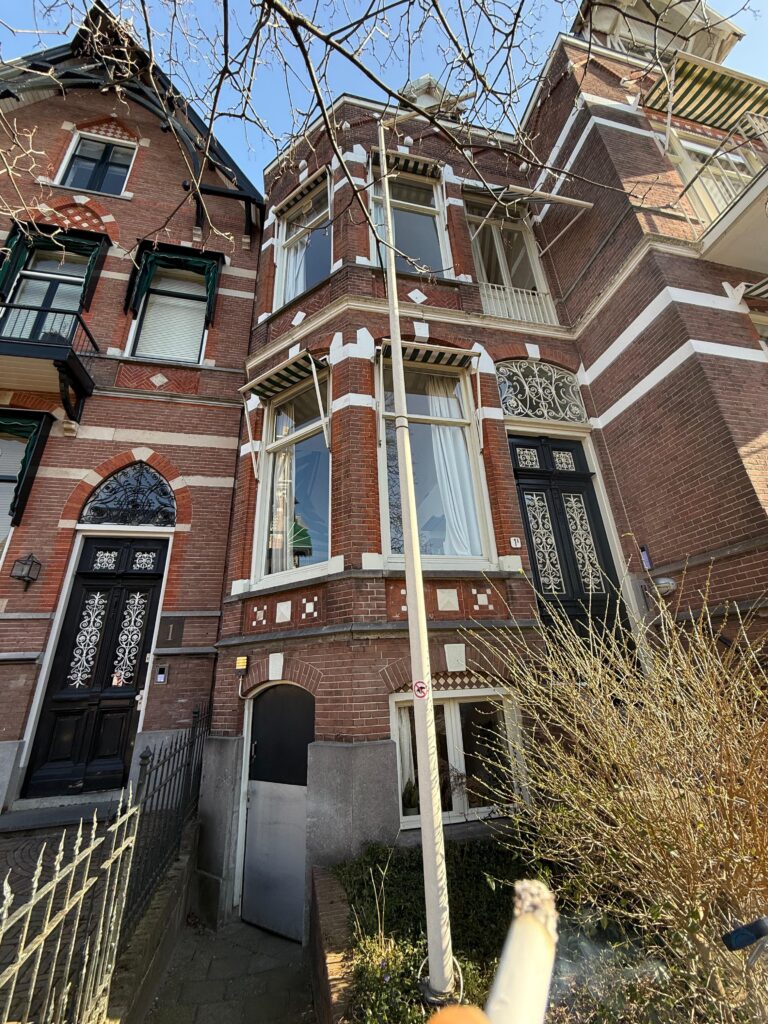 Karakteristieke bakstenen gevel met erker en lichte houten raamkozijnen