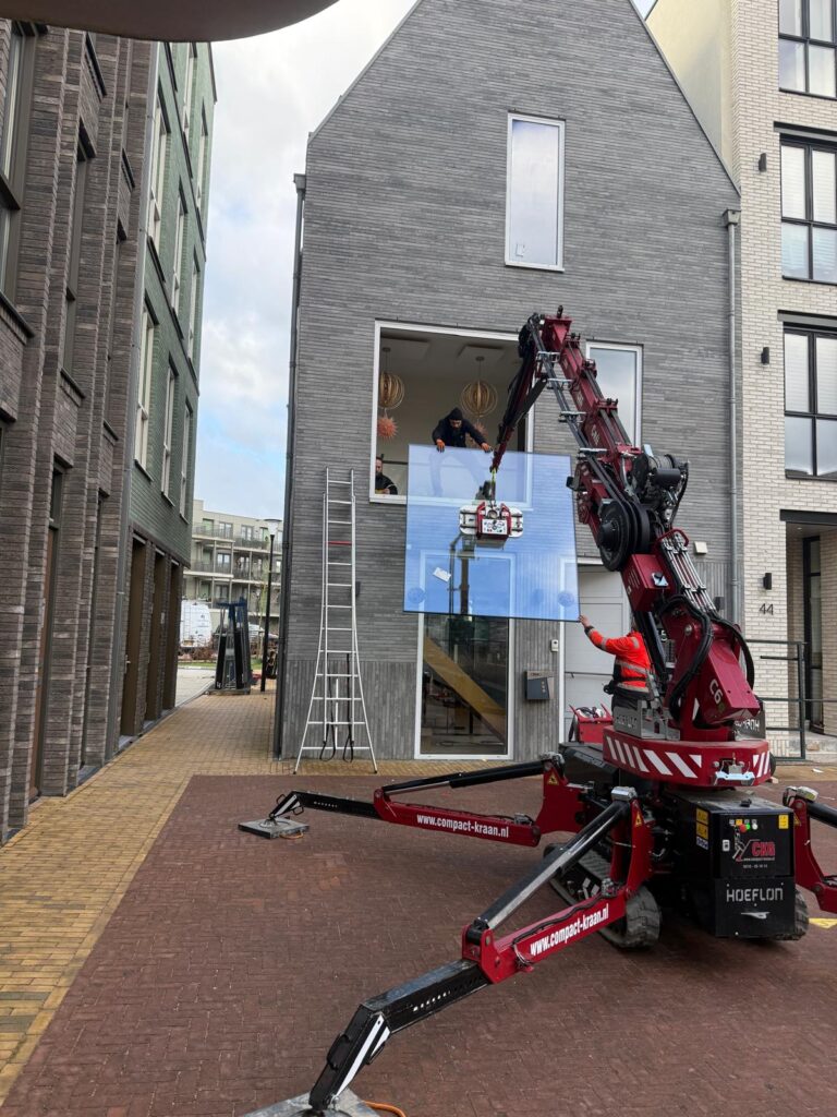 Glaszetters plaatsen een grote ruit met een compacte glaskraan