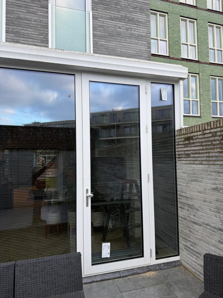 Witte tuindeuren en zijraam met beglazing