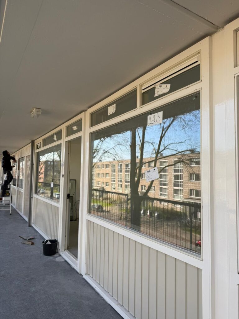 Brede raampartij met bovenlichten, gezien vanuit een overdekte ruimte