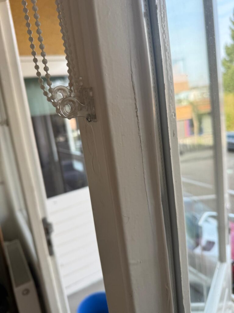 Detail van beglazing in een wit houten raamkozijn